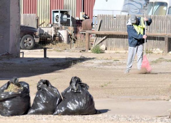 GARY ROACH is finishing clean up of the vacant lot next to the empty Family Dollar building during Clean Up day downtown on Saturday, Dec. 11. He picked up three large bags of litter. (Photo by Ann Reagan)