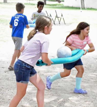 A group of kids at the Lamb County Leaf Day Camp uses teamwork and noodles in a race to see who could get the soccer ball into a bucket the fastest on Tuesday, during day one of the two-day camp. (Staff Photo by Derek Lopez)