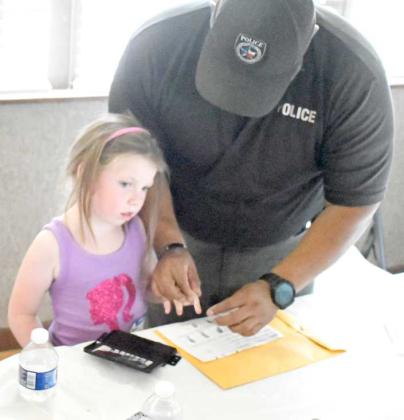 A young lady at the Lamb County Leaf Day Camp got her finger prints taken by LPD Sgt. Pedro Cruz on Tuesday. (Staff Photo by Derek Lopez)