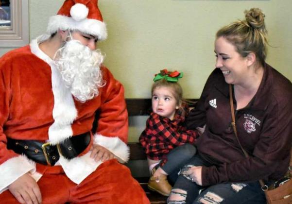 JESSA MCKINNON is not sure about Santa, and is holding fight to her mother. (Photo by Krista Carpenter)