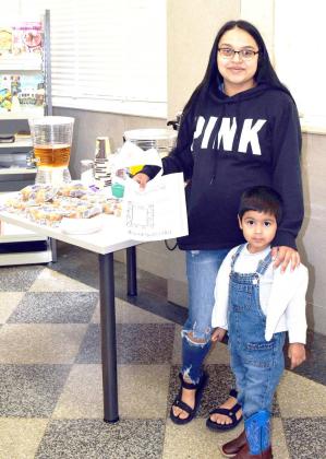 CORRECTION TO PHOTO: Tytus Ramirez and his mom, Ida, enjoy 'Muffins for Moms' on Saturday, May 13,2023, and prepare to color some pictures at the Lamb County Library and just relax during the rainy morning. The Library offers special treats on many occasions and encourages all residents of the county to come in and browse, to do research, bring the kids to encourage a love of reading, or just come in for a time and read.