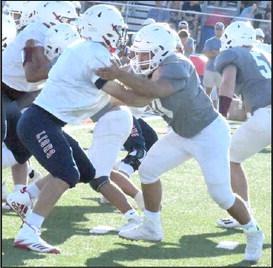 HOLDING YOUR BLOCK - Littlefield sophomore tackle, Marcquis Rosemond, locks on to a defender, getting his block, giving quarterback, Chip Green, time in the pocket, during the live quarter portion of their scrimmage on Friday against the Lions at Trinity Christian. (Staff Photo by Derek Lopez)