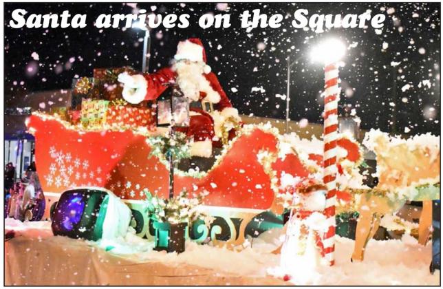 LET IT SNOW – Santa’s sleigh pulled by his reindeer are featured in the Christmas Parade that took place as part of the Christmas on the Square event last Thursday, Dec. 16 th . This float was sponsored by Lowes Food King. (Staff Photo by Derek Lopez)