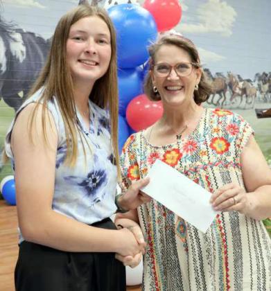 The Lamb County Adult Leaders awarded two $500 scholarships to Kauy Carr, left, and Garicyn Bigham, who was not present at the banquet. Connie Burt, right, prensent the award at the Lamb County Awards Banquet. (Photo by Ann Reagan)