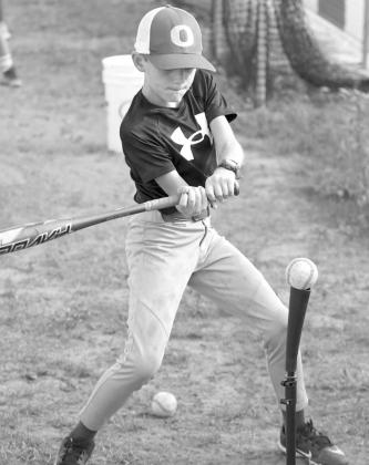 A camper during the morning session of the Olton Youth Baseball Camp gets some cuts in off of the tee, during a hitting drill last Thursday. (Staff Photo by Derek Lopez)