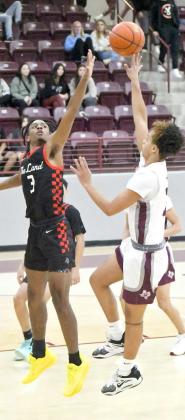 Littlefield junior, Ryan Williams, puts up a floater from the left side over Levelland’s Eryk Jones, during the first half of the Wildcats’, 72-34, victory over the Lobos at Wildcat Gym on Tuesday in nondistrict play. (Staff Photo by Derekl Lopez)