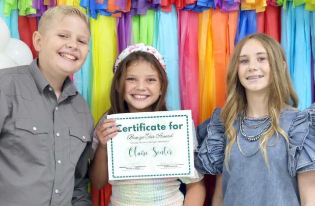 Jack Reese, left and Paisli Clanch, far right, present the Bronze Star Award to Claire Senter, middle, during the Lamb County 4-H Banquet on Saturday, August 17, 2024. (Photo by Ann Reagan)