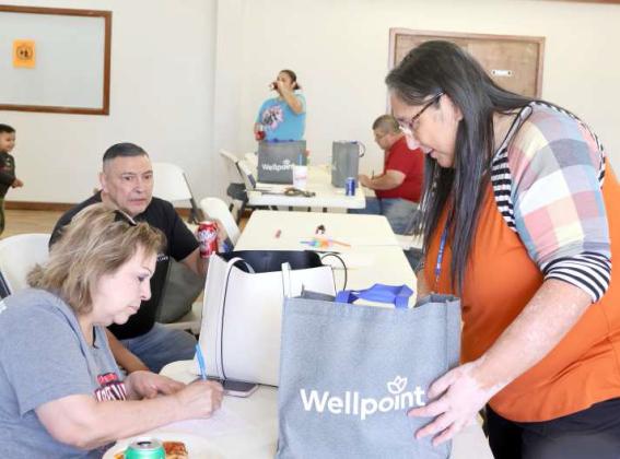 Left to right, Jesusa Garcia receives information and hygiene bag from Gracie Perez. (Photo by Ann Reagan)