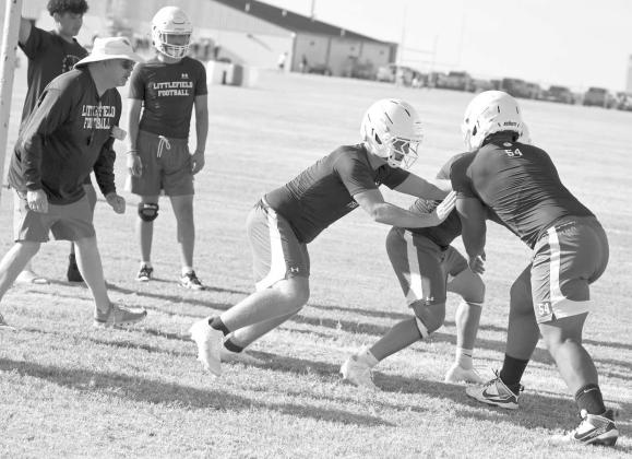 The Littlefield Wildcats’ linemen work on technique and getting to their blocking asignments, during the first day of two-a-days Monday morning. (Staff Photo by Derek Lopez)