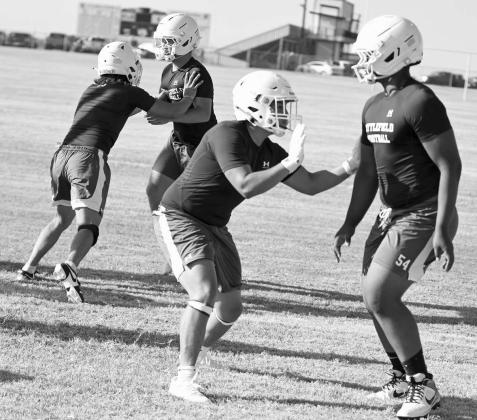 The Littlefield Wildcats’ linemen work on technique and getting to their blocking asignments, during the first day of two-a-days Monday morning. (Staff Photo by Derek Lopez)