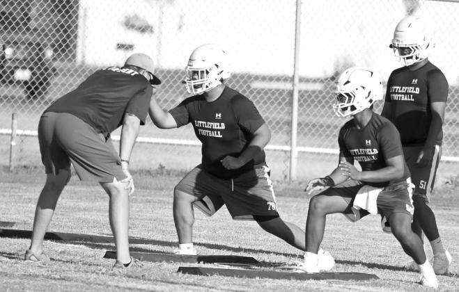 The Littlefield Wildcats’ linemen work on getting their steps right with Coach Hartley, during the first day of two-a-days Monday morning. (Staff Photo by Derek Lopez)