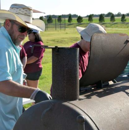 Volunteers help cook burgers provided by First United Bank for the Littlefield Chamber of Commerce’s free Pool Party at the Littlefield Aquatic Center on Aug 3. (Photo by Leon Szaniszlo).