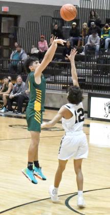 LETTINGIT FLY— Springlake-Earth junior, Evan DeLeon, fires up a three from the top of the key over the Muleshoe defense, during the Wolverines victory over the Mules on the road on Saturday. (Staff Photo by Derek Lopez)