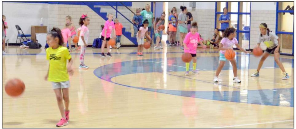 GIRLS OF SESSION TWO of basketball camp were practing dribbling the ball on Monday. The girls spent the morning practicing dribbling, passing and shooting the ball. (Staff Photo by Samantha Pontius)