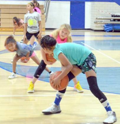 The girls of session two were practicing dribbling the ball in a figure 8 motion around and through their legs. (Staff Photo by Samantha Pontius)