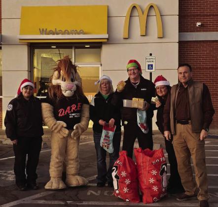 The Lamb County Sheriff’s Office held their annual Pie Drive on Dec. 18th, where the proceeds go towards their Christmas for Kids Toy Drive. (Shown): Birdy Monotya-Coronado, Darren the D.A.R.E. Lion, Ann Robison, Michael Armstrong, Misty Dias and Sheriff Gary Maddox. (Staff Photo by Derek Lopez)