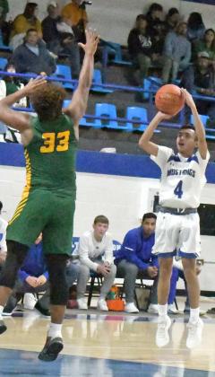 SHOOTING THE THREE – Olton’s Alex Santillan (4), fires up a three form the right elbow over the outstretched arm of Springlake-Earth’s, Keshan Holmes (33), during the Mustangs victory over the Wolverines on Tuesday at Mustang Gym. (Staff Photo by Derek Lopez)