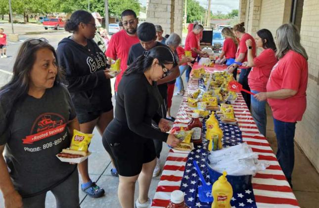 Atendees of First Federal Bank’s 3rd of July event lined up to get a free hot dog, chips, cookie and water last Thursday. People who attended the event were also able to sign up for a chance to win door prizes. (Staff Photo by Derek Lopez)