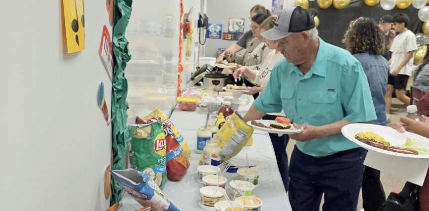 Staff and family members of the retirees go through the food line during the retirement luncheon last Friday at Primary Campus. (Staff Photo by Derek Lopez)