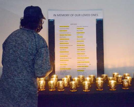 A woman stands by to read the names of the members of the Littlefield community that have passed away since 2019. Each name was then read out by a friend or relative of the deceased and a candle was lit and placed on a table in honor of their memory. (Photo by Sam Pontius)