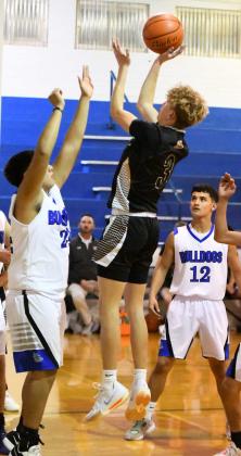 Sudan’s Aspen Reyher (3) puts up a lay-up in the lane over Amherst’s Guillermo Pacheco, during the second half of the Hornet’s road victory over the Bulldogs in Amherst on Tuesday. (Staff Photo by Derek Lopez)
