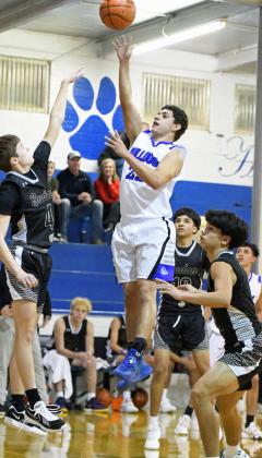 Amherst’s Kevin Garcia (22) puts up a floater in the lane, during the first half of the Bulldog’s home loss to the Hornets in Amherst on Tuesday. (Staff Photo by Derek Lopez)