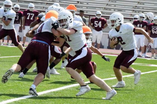Littlefield’s Jakob Kirkland holds his block, as running back, Major McNeese (2), looks for a hole to run through, during their intersquad scrimmage on Saturday at Wildcat Stadium. (Staff Photo by Derek Lopez)