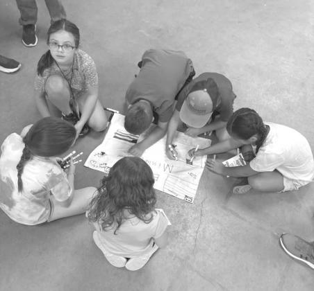 Campers at the 4-H Project Camp are shown making group flags, during day one of Project Camp on Monday at the Lamb County Ag Center. (Submitted Photo)