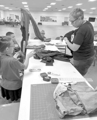 Campers at the 4-H Project Camp are shown working on turning blue jeans into laundry bags, during day one of Project Camp on Monday at the Lamb County Ag Center. (Submitted Photo)
