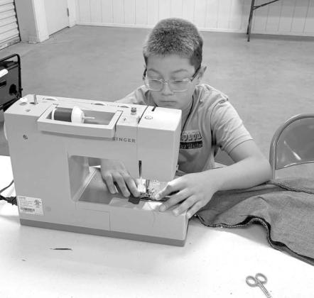 Campers at the 4-H Project Camp are shown sewing their first seams on their blue jean laundry bags, during day two of Project Camp on Tuesday at the Lamb County Ag Center. (Submitted Photo)
