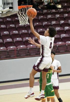 Kam McCarty (4) drives in for a lay-up on the left side, during the first half of the Wildcats’, 58-52, victory at Wildcat Gym in Littlefield on Tuesday. (Staff Photo by Derek Lopez)