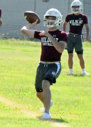 Littlefield varsity quarterback Chip Green fires a pass to his left during team offense drills, during the first day of two-a-days on Monday. (Staff Photo by Derek Lopez)