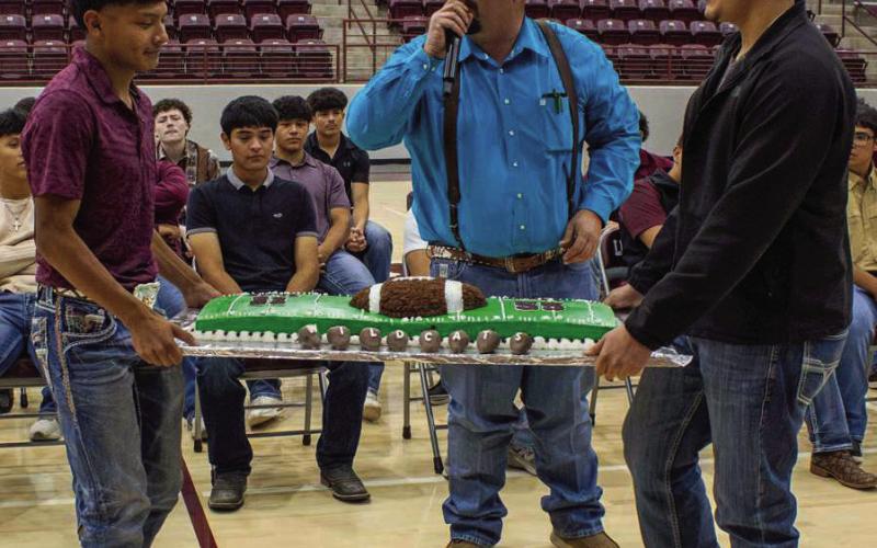 Zane Champion and Uriel Ibarra show-off their cake as the auctioneer auctioned off the cake to the highest bidder, during the annual cake auction at LHS on Wednesday, April 1st. This cake sold for $ 1,300. (Photo by Madison Vidales)